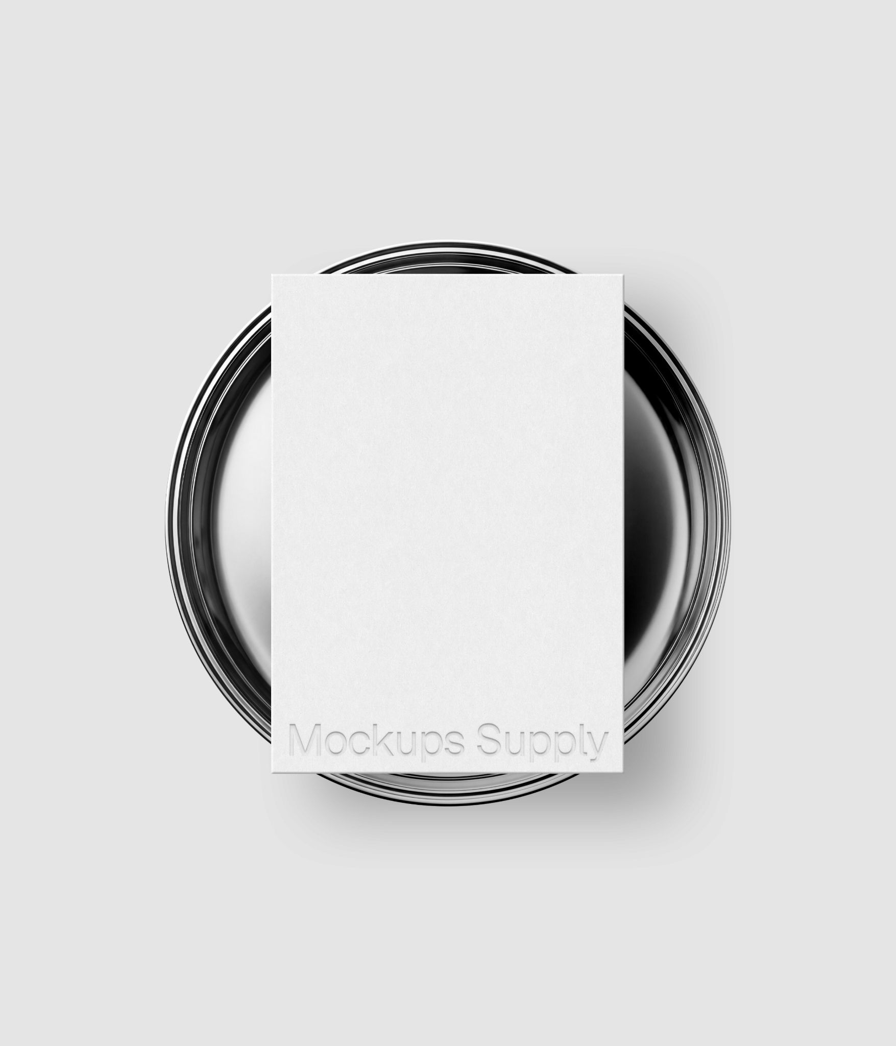 Paper card mockup with embossed typography on circular metal plate for logo design and identity showcase