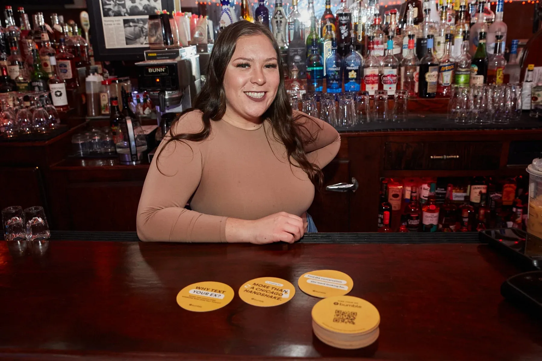 Bartender with Bumble coasters displayed on the bar