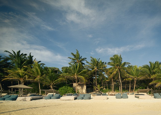 Group of people discussing their spiritual yoga journey on the beach at Nomade Holbox in Tulum Mexico, with a serene and peaceful atmosphere