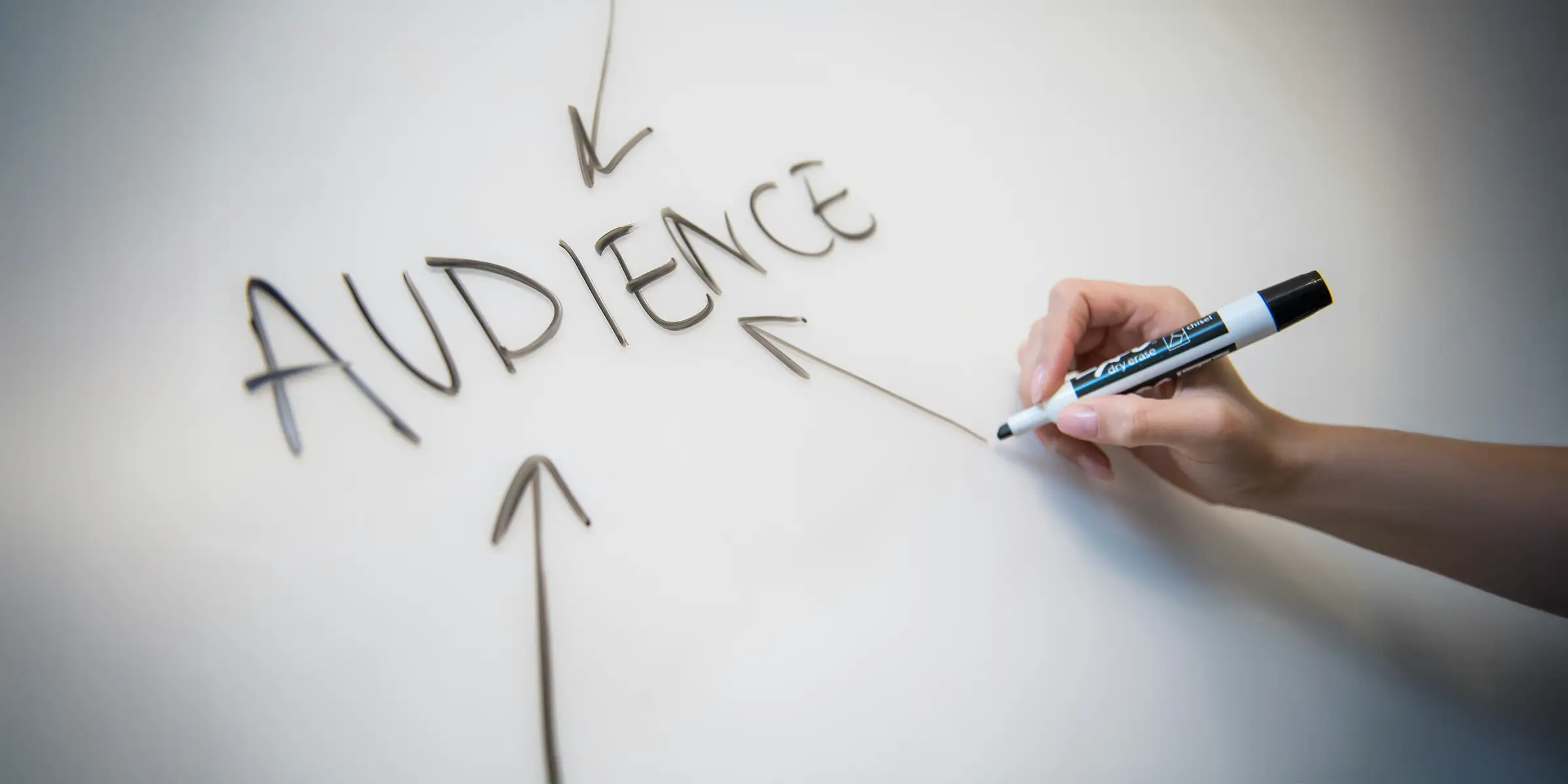 image of a drawing on a whiteboard with the text "audience" and 3 arrows pointing towards it with one of them ending with a persons hand holding a marker pen