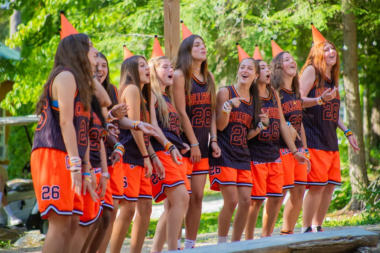 Camp Lenox cheerleaders in uniform cheering at an event