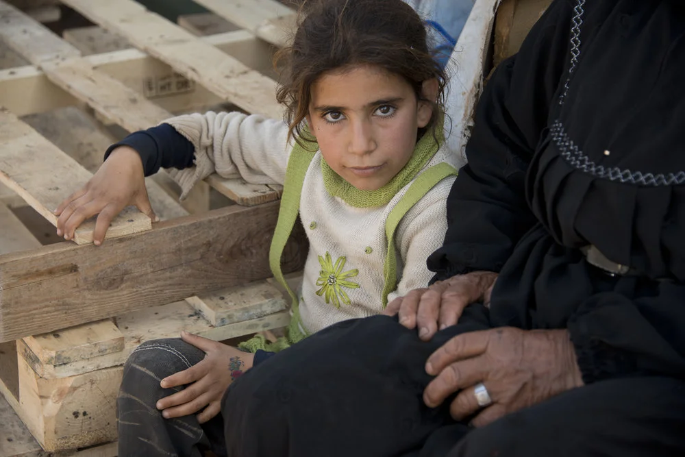 Two children sitting on wooden pallets