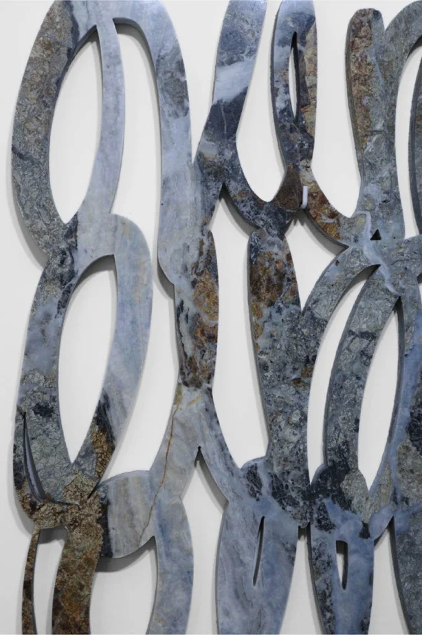 Scultura astratta in pietra grigia con forme intrecciate, opera contemporanea iStone Arte che esplora geometrie fluide e texture naturali per valorizzare brand artistici