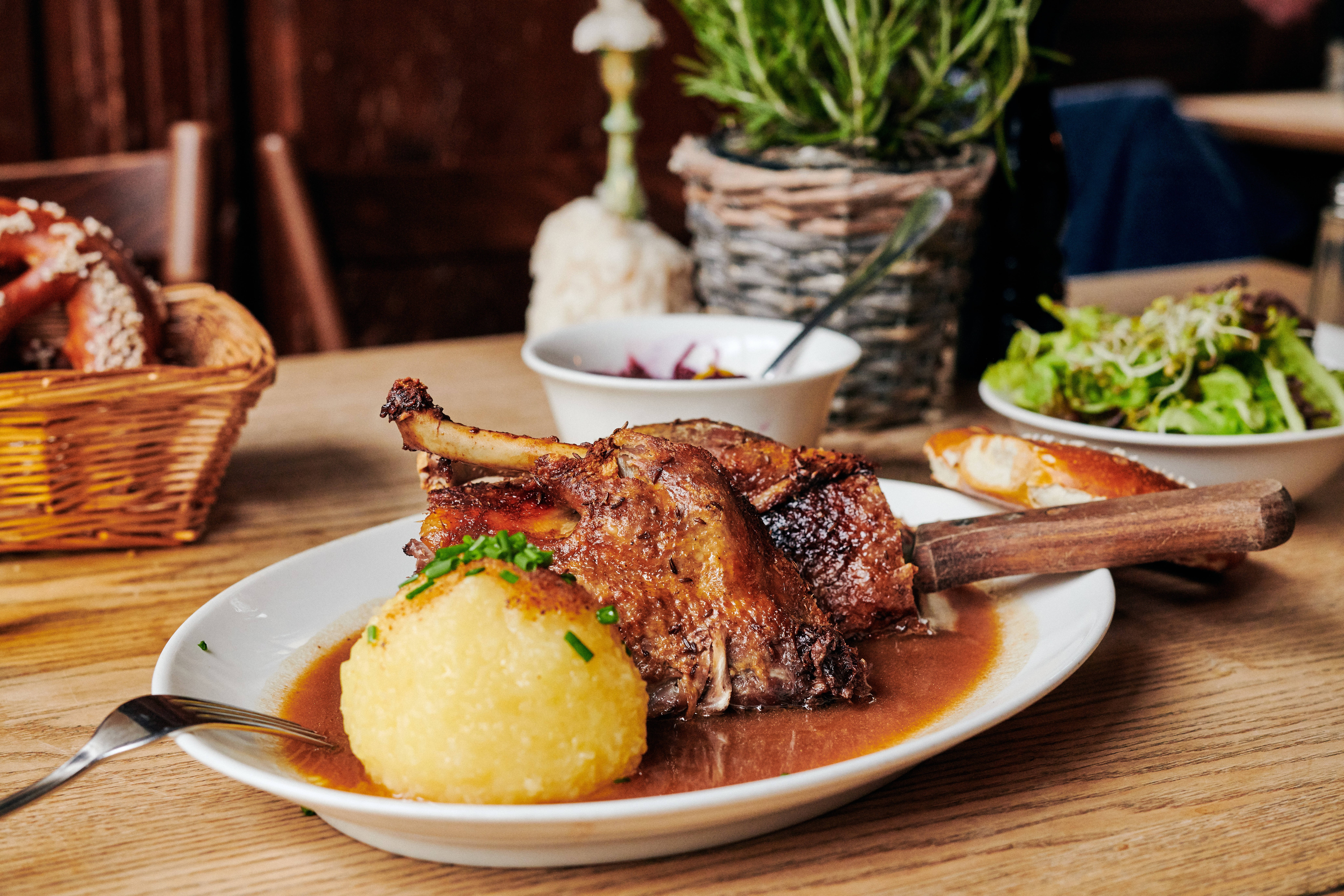 Kopf & Gaumen Gänsebox mit saftiger Gänsekeule, Rotkohl, Grünkohl, zwei Kartoffelknödeln und winterlichem Dessert als festliches Weihnachtsmenü.