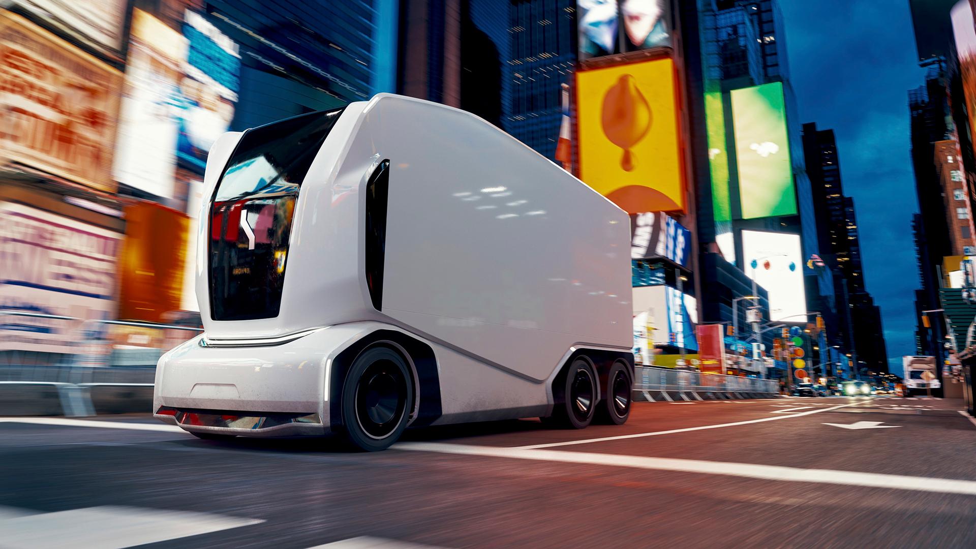 Einride's autonomous vehicle driving through a busy city street at dusk.