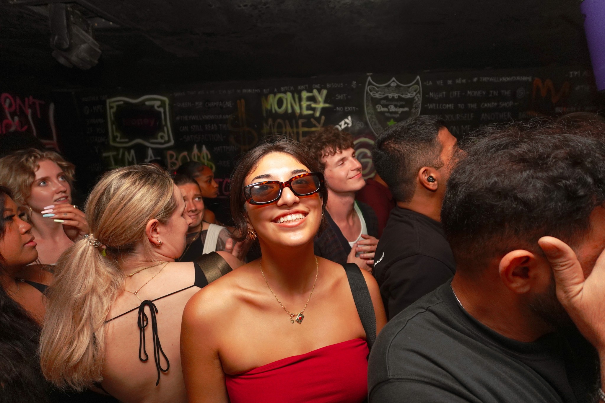 Young traveler smiling inside a crowded nightclub during a bar crawl in Nice capturing the difference between bar crawl social vibes and nightclub tour party atmosphere in the French Riviera