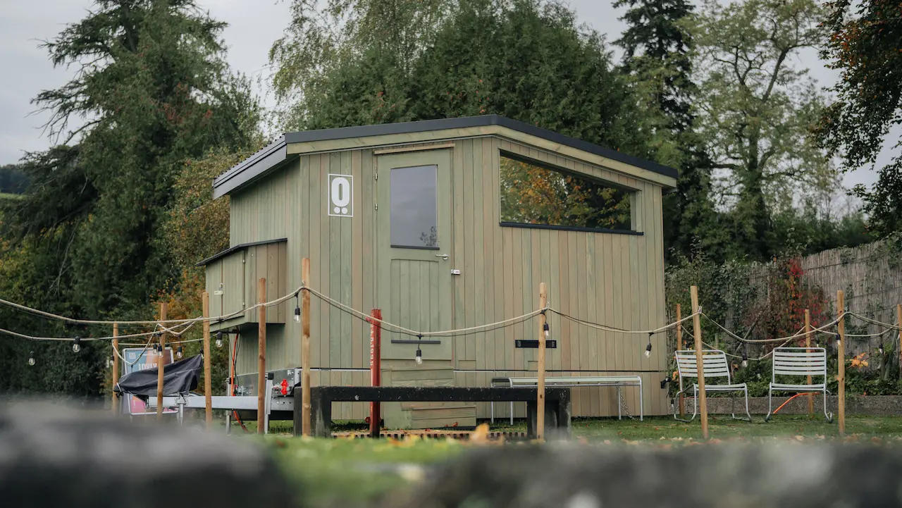 Elf woman in white dress raising hands by the river