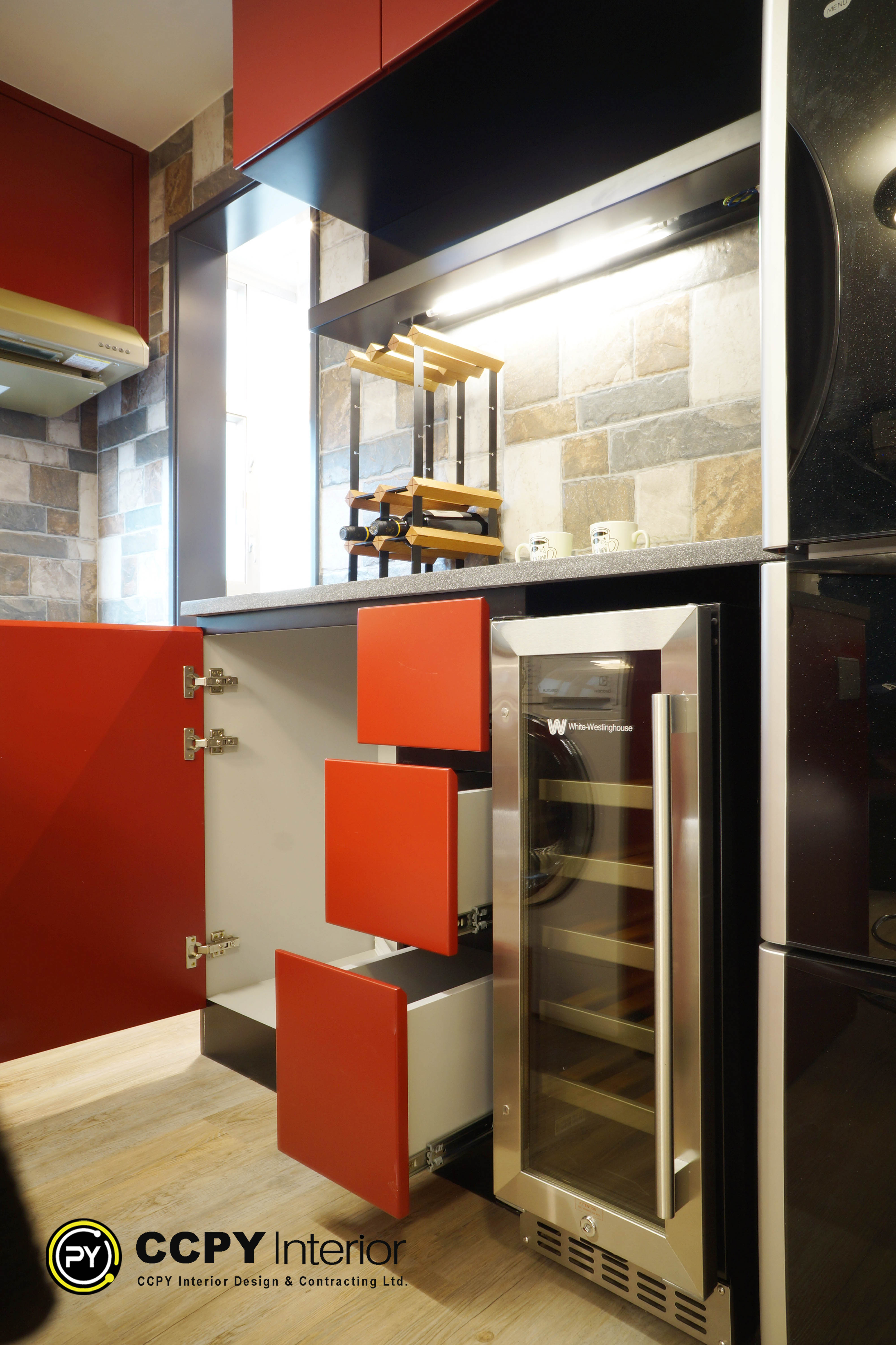 The selected region shows an orange and dark grey kitchen or bar cabinet area featuring a built-in White-Westinghouse compact beverage refrigerator or wine cooler.Appliance DetailsBrand: White-Westinghouse (indicated by the "W" logo and brand name on the glass door).Type: Built-in under-counter beverage/wine refrigerator.Finish: Stainless steel frame with a tinted glass door.Cabinetry: Modern handleless orange doors and custom pull-out drawers.