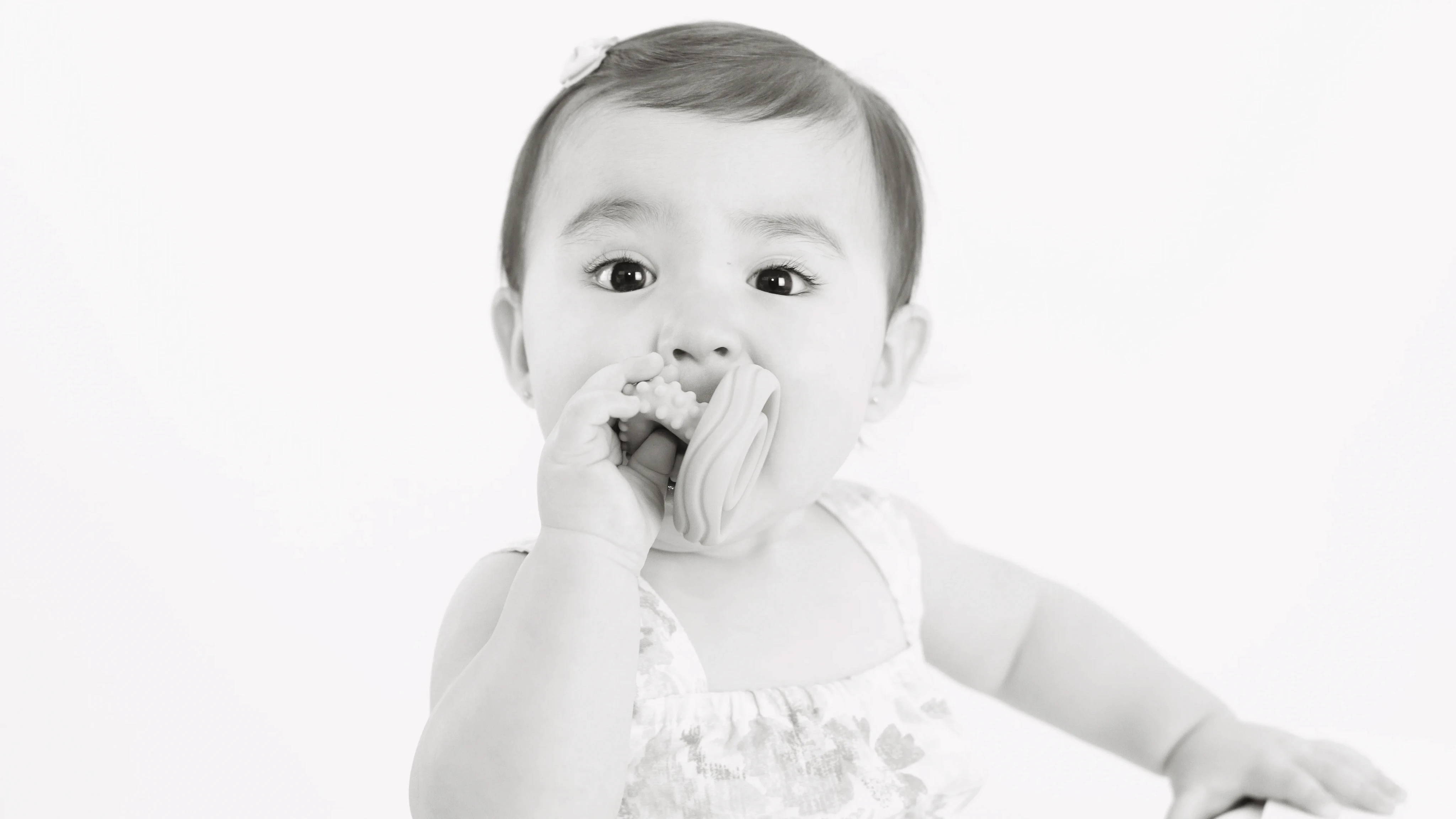 Retrato en blanco y negro de bebé llevándose su dedo a la boca