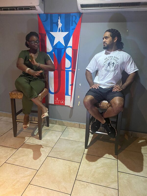 Interview subject seated in front of a Puerto Rico flag during documentary filming