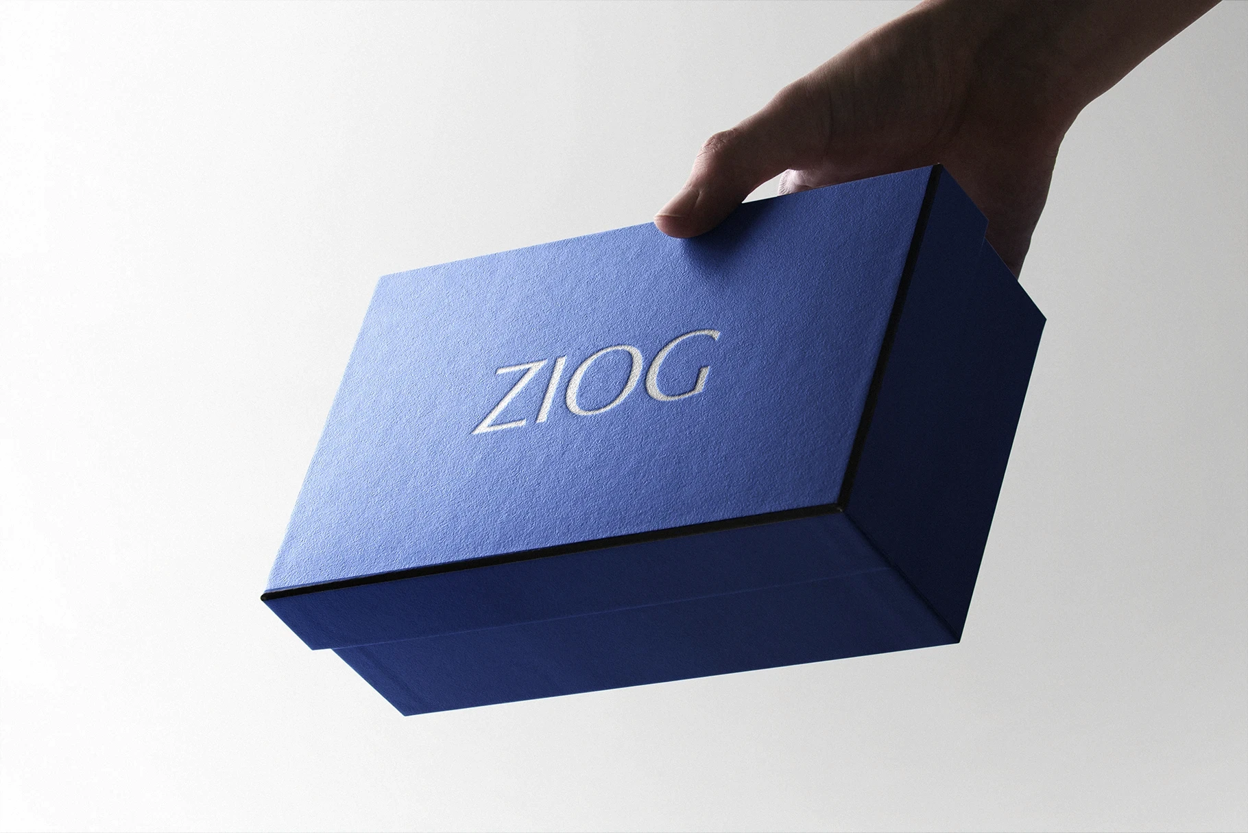 Luxury product box mockup in a deep blue color with a white logo.