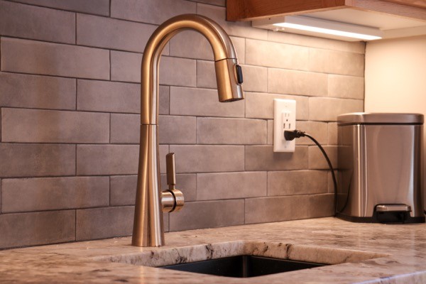 Silver faucet slate tile backsplash and light quartz countertops
