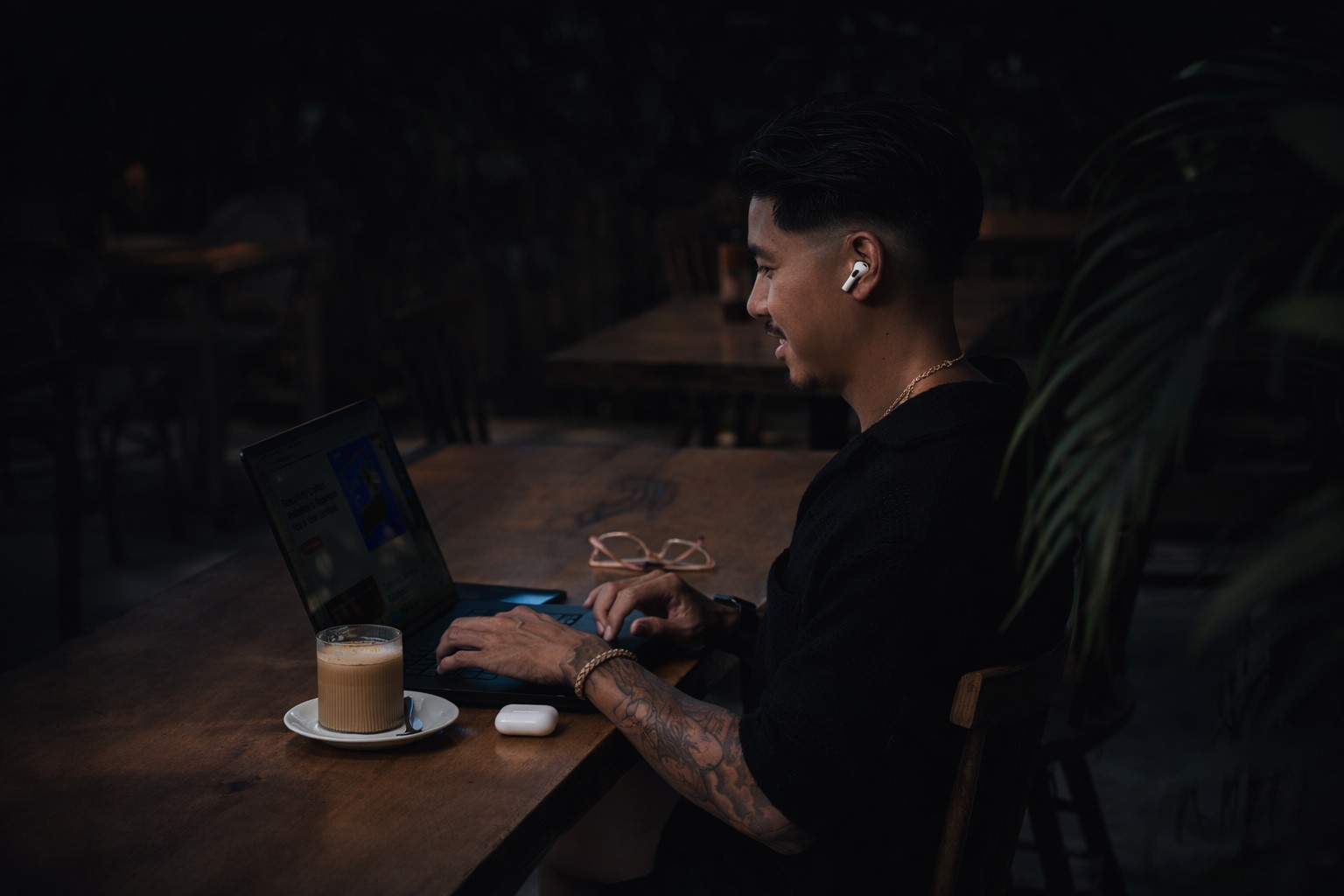 A modern black speaker illuminated by soft light, set against a green background.