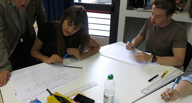 students practicing writing letters