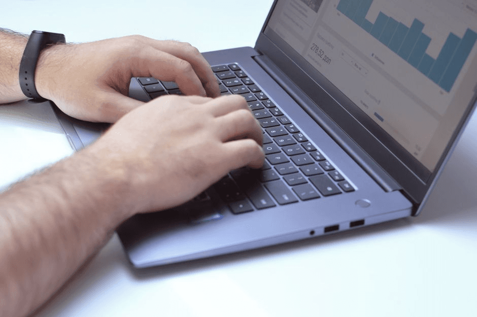A laptop displaying marketing dashboards and content planning tools on a small business desk.