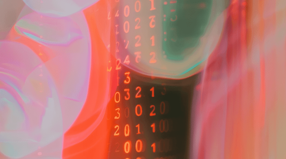 Blurry image of a computer screen displaying a series of numbers in various colors and sizes.