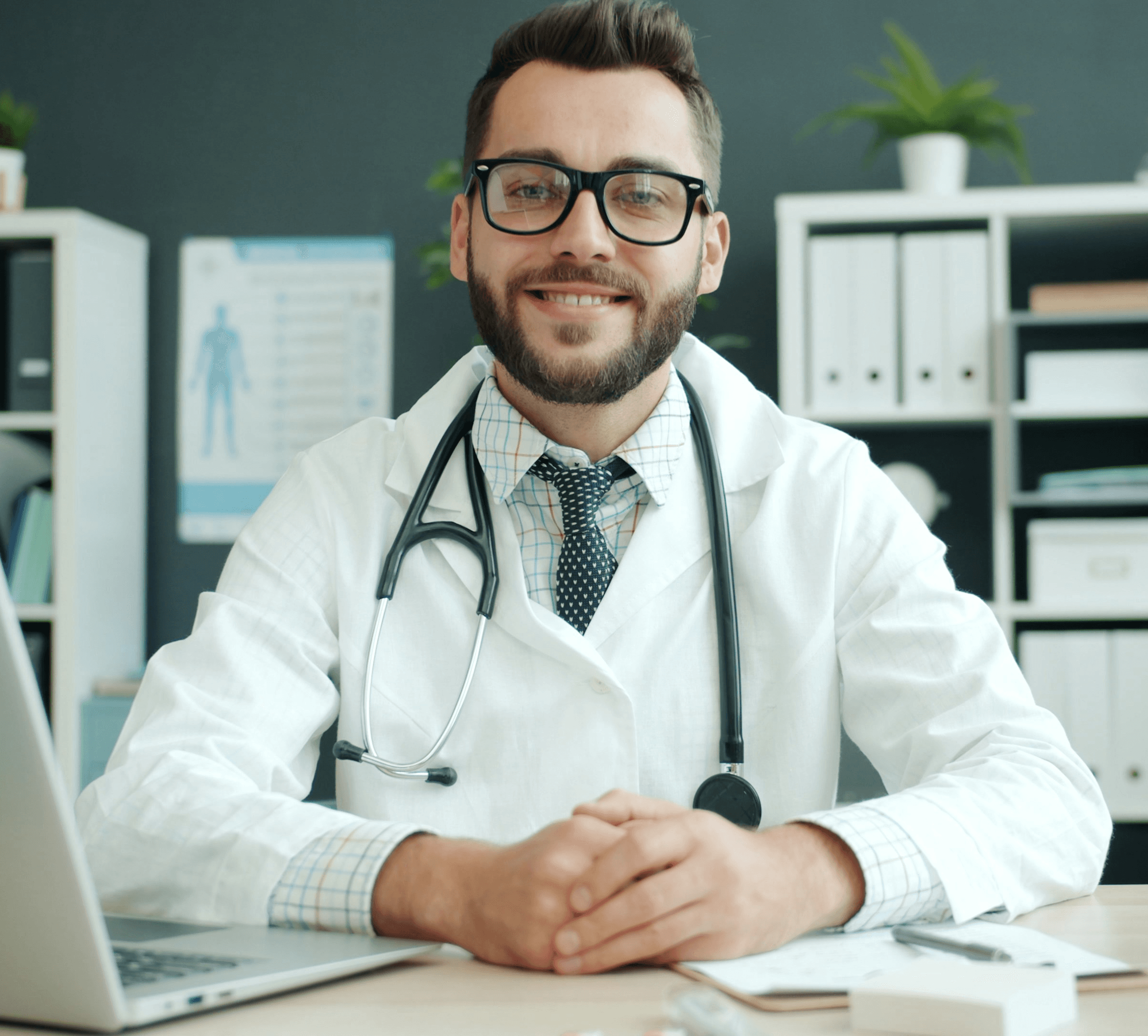 Doctor wearing a stethoscope sits at a desk.