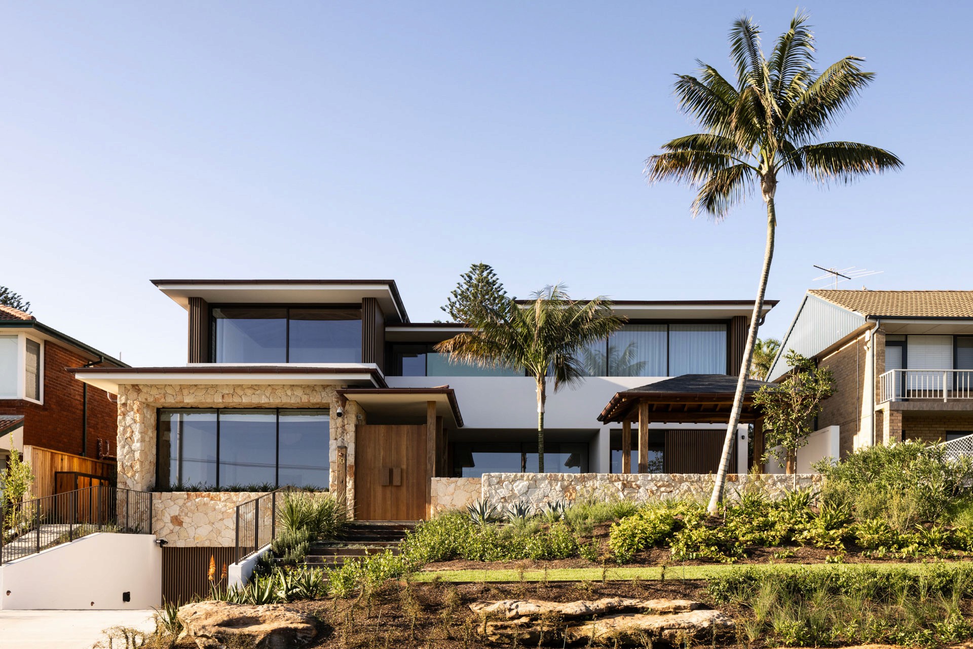 Modern commercial space with a slanted roof, surrounded by greenery and a spacious outdoor area.