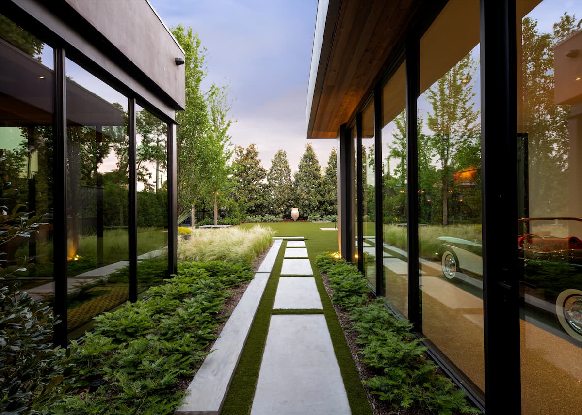 Modern geometric walkway with large format pavers and ornamental grasses in contemporary Dallas landscape design