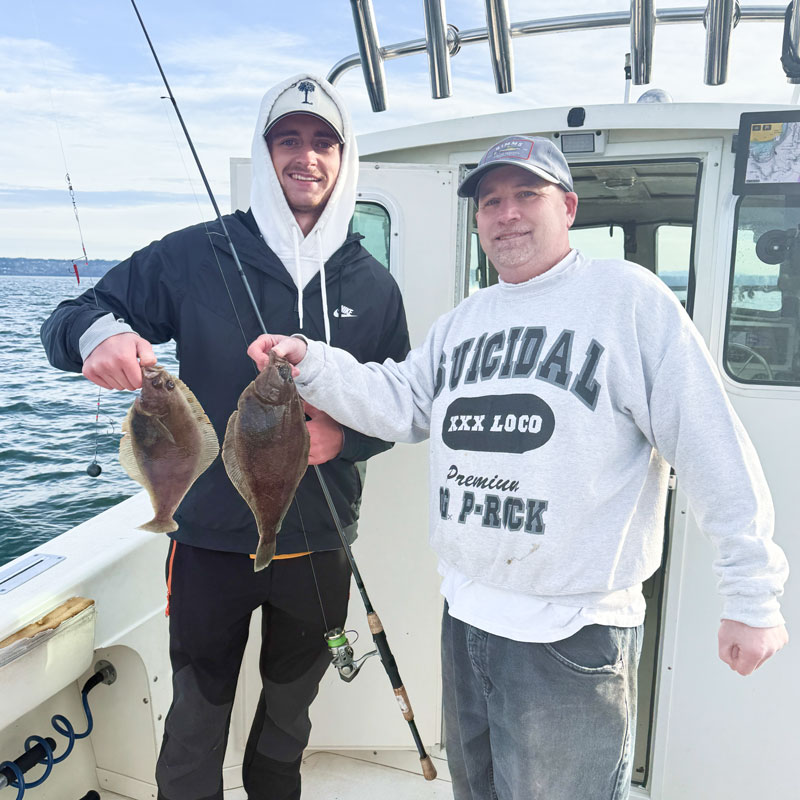 Father and son fishing for flounders on a boat