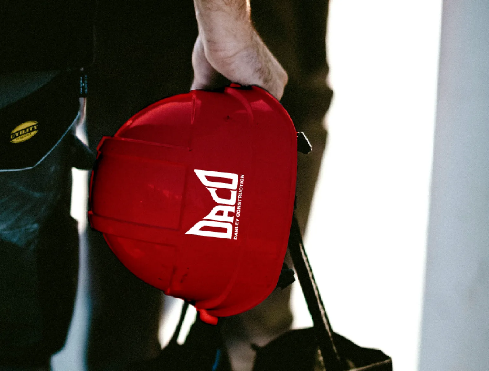 A red hard hat with the DACO logo printed on it.
