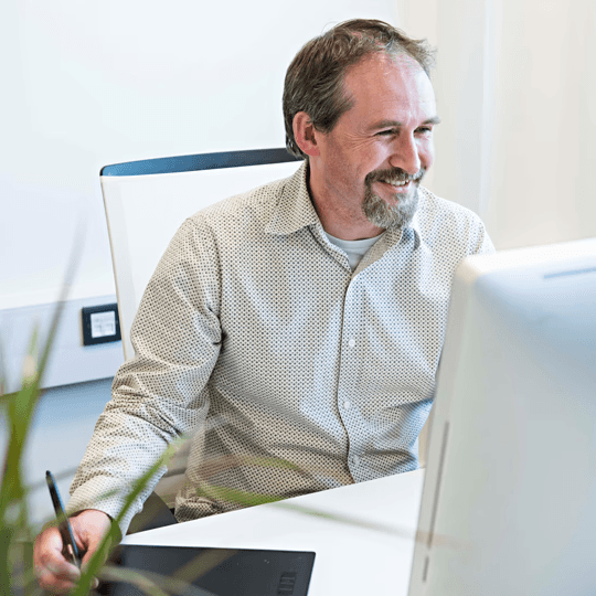 Male working at a large screen using a drawing tablet