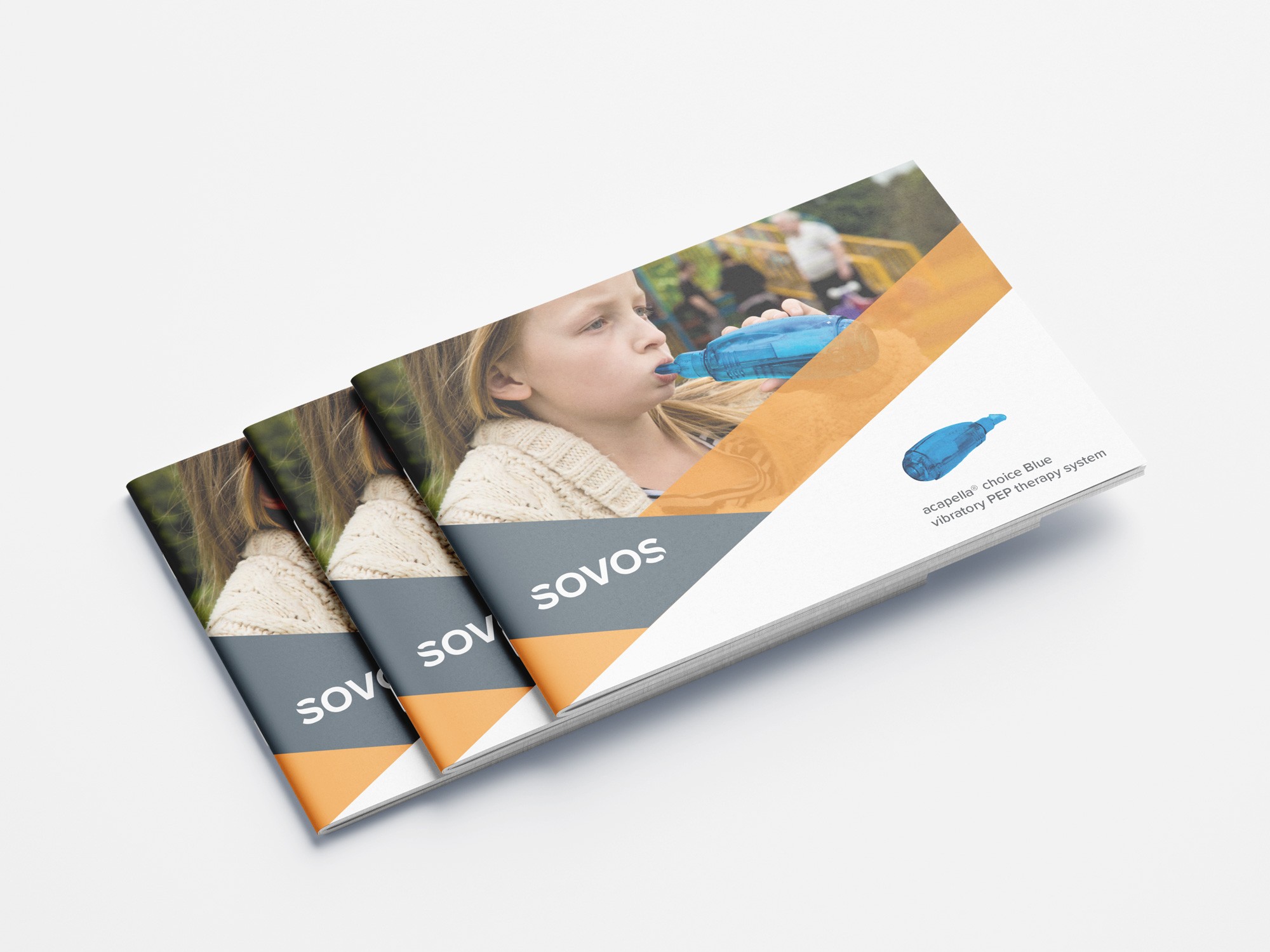 Three stacked landscape booklets with a partial cover image of a child using a breathing apparatus. The cover features an orange and gray geometric design with the text "SOVOS" written on it.