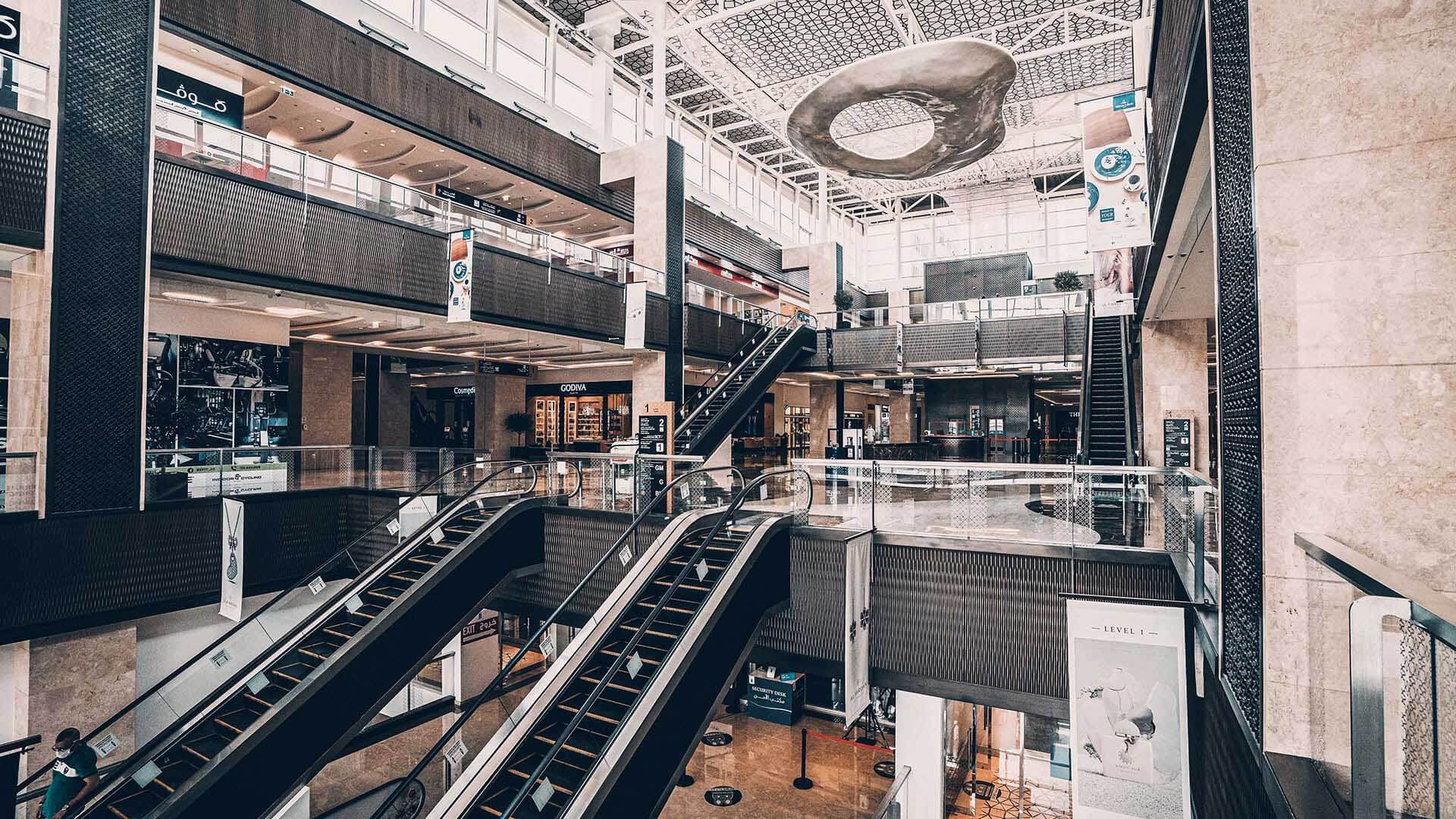 Wide view of Nation Towers Mall interior, showing luxury shops, modern architecture, and multiple escalators.