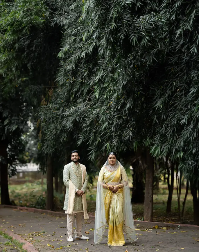 A spirited moment from a wedding in Hyderabad, showcasing elegantly dressed Telugu couple, posing candidly in a park. Photo by Out of The Blues Fine Art Wedding Photography.