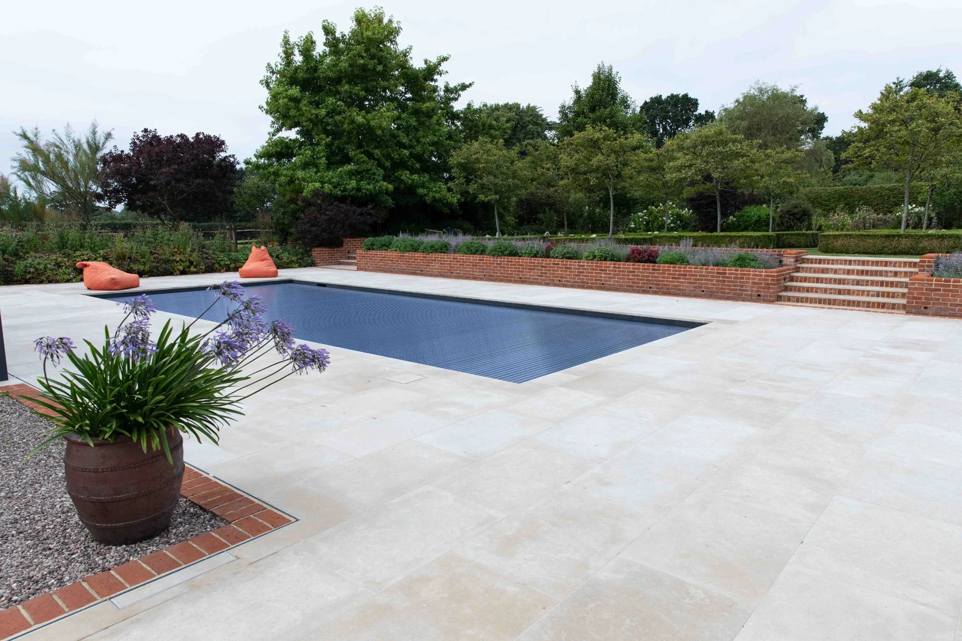 Modern bedroom with large blue wardrobe, a window with a view, and a patterned bedspread.