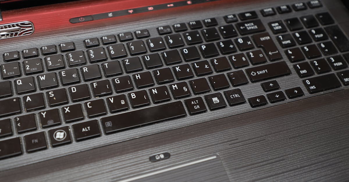 Detailed view of a vintage Qosmio laptop keyboard with a distinct European key layout.