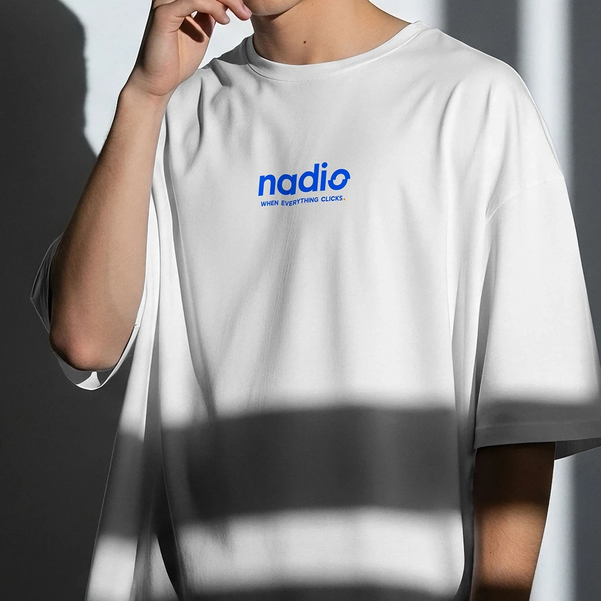 Person wearing white t-shirt with blue nadio logo and text when everything clicks.