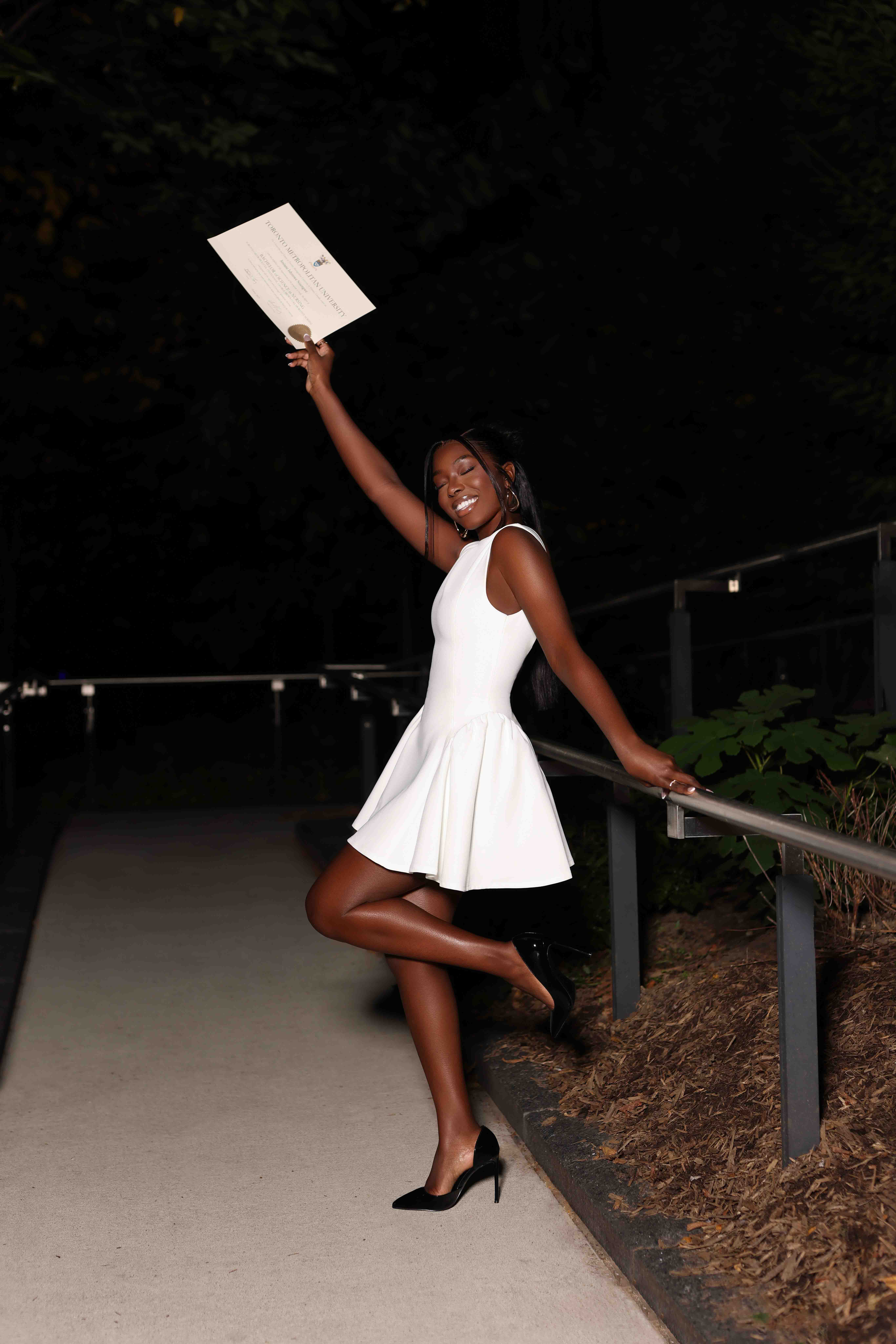 Graduate holding up a diploma during a night celebration