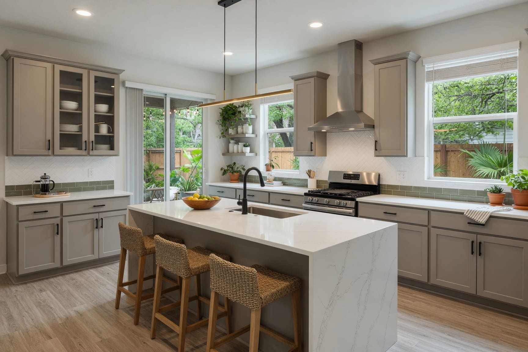 Kitchen with marble island, wicker bar stools, and garden window