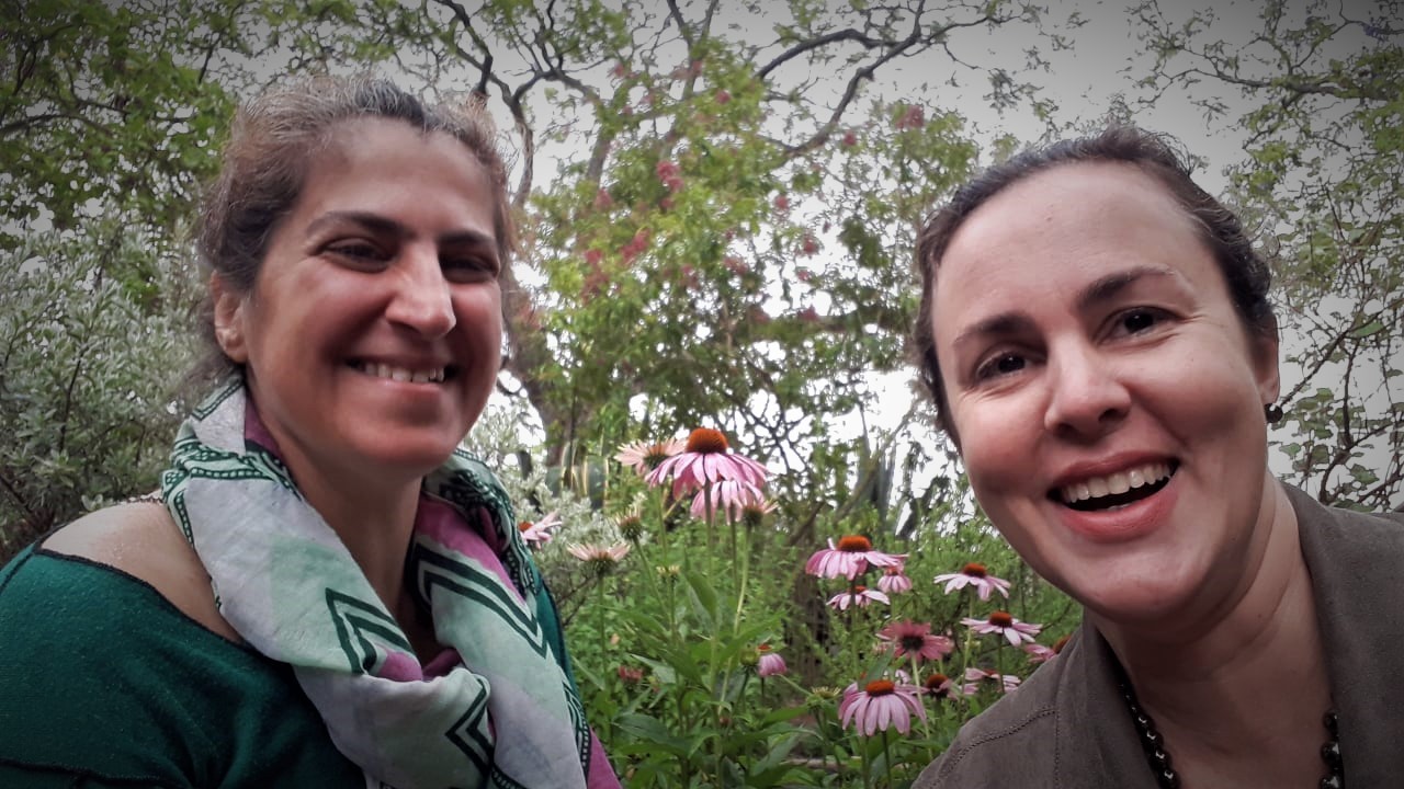 Elsa Breia, à esquerda, e a dra. Rosa sorriem em selfie diante de flores no Jardim Botânico da Ajuda