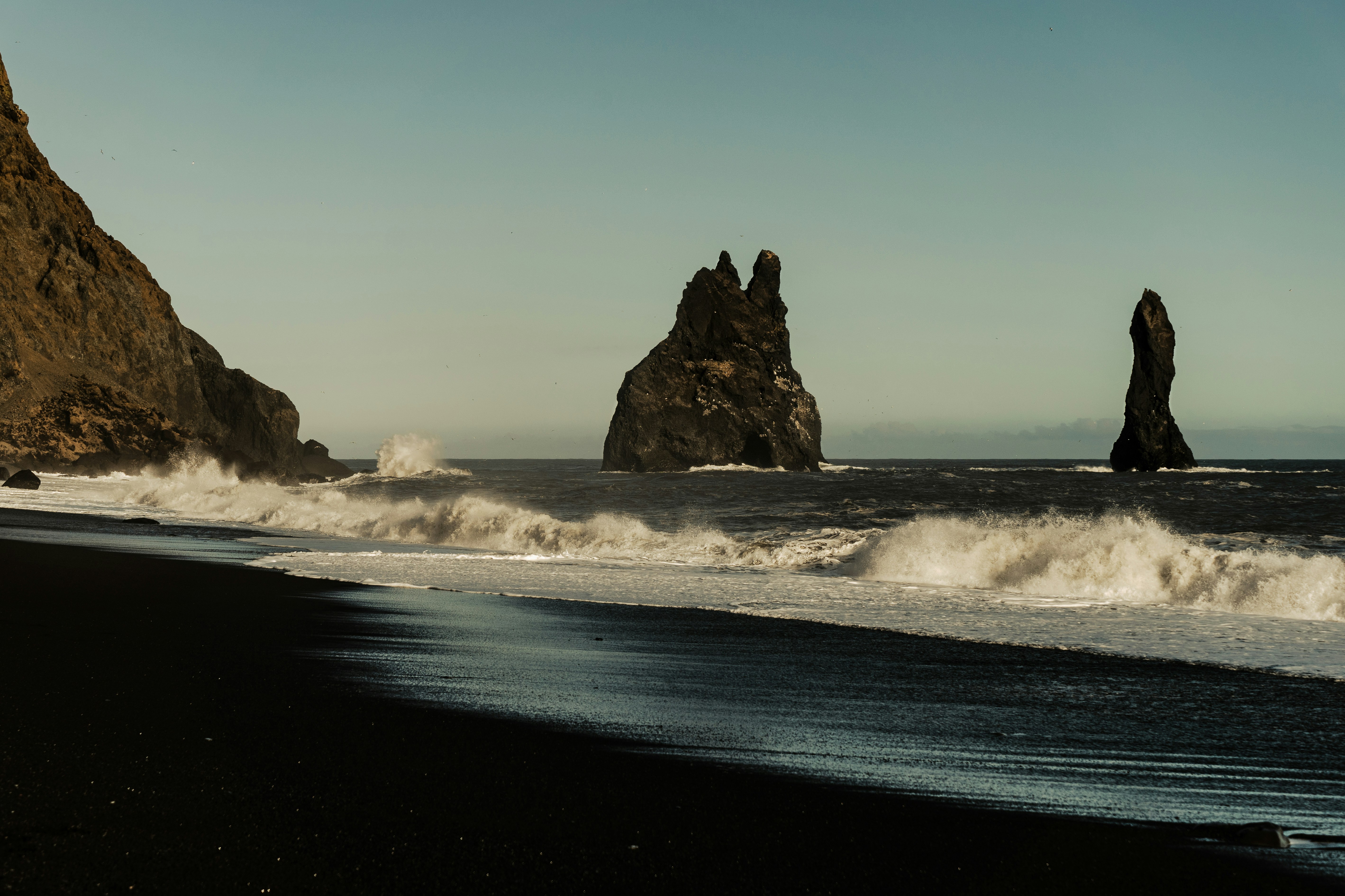 Reynisfjara black sand beach with views of the Reynisdrangar sea stacks in Iceland.