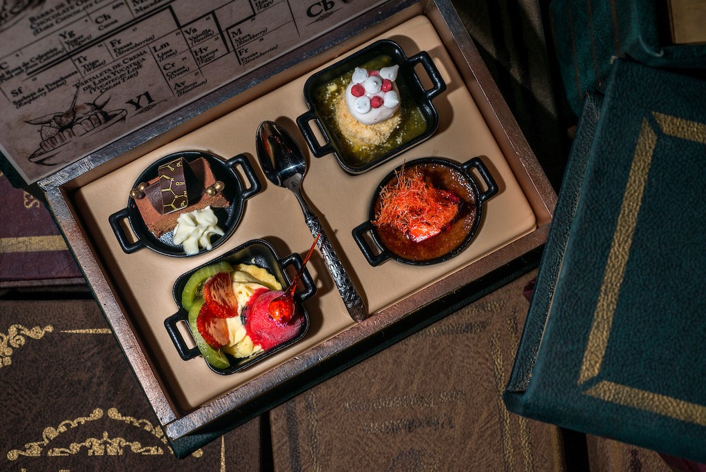 Couple standing on a balcony with binoculars in hand looking out over the ocean