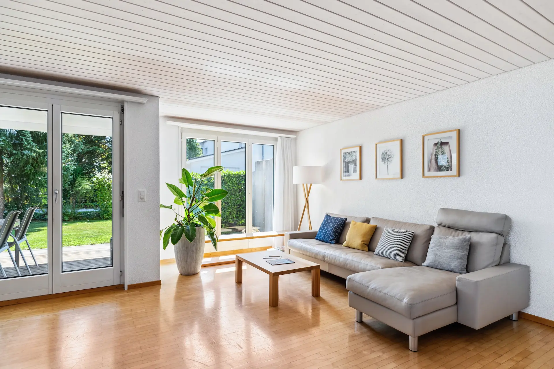 Helle Wohnzimmerecke mit gemütlichem Sofa und Blick in den Garten