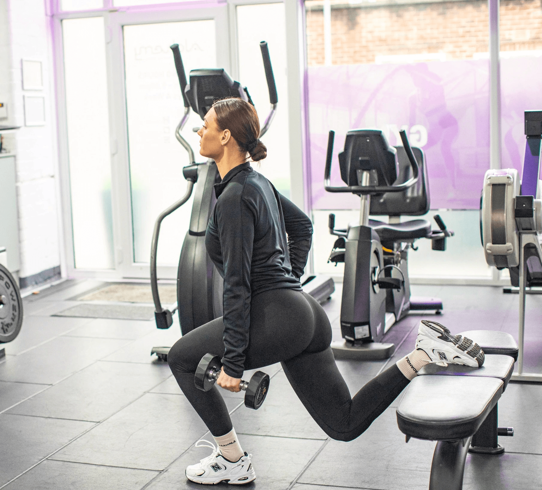 A personal coach is smiling with his arms crossed, wearing a black