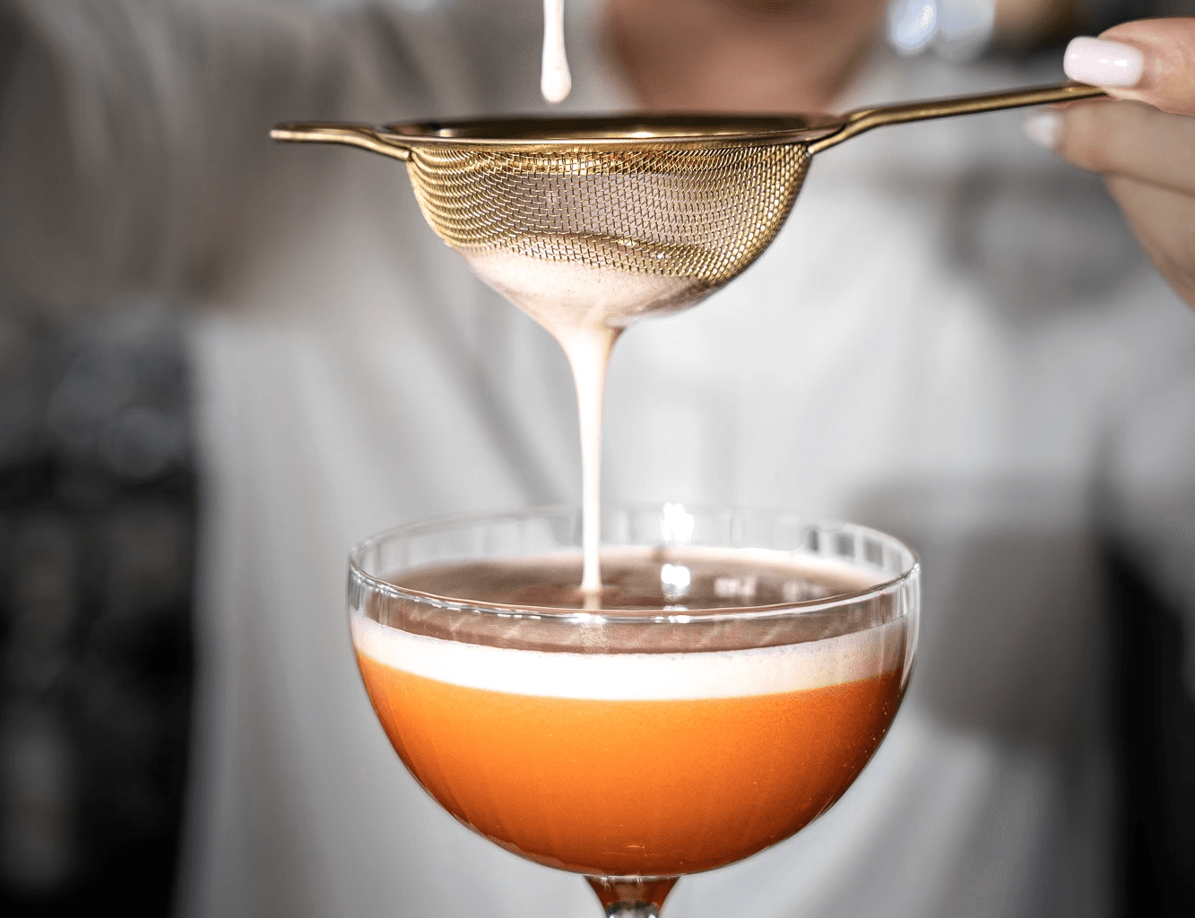 elegancki koktajl przygotowywany przez barmana na wesele przy pomocy sitka