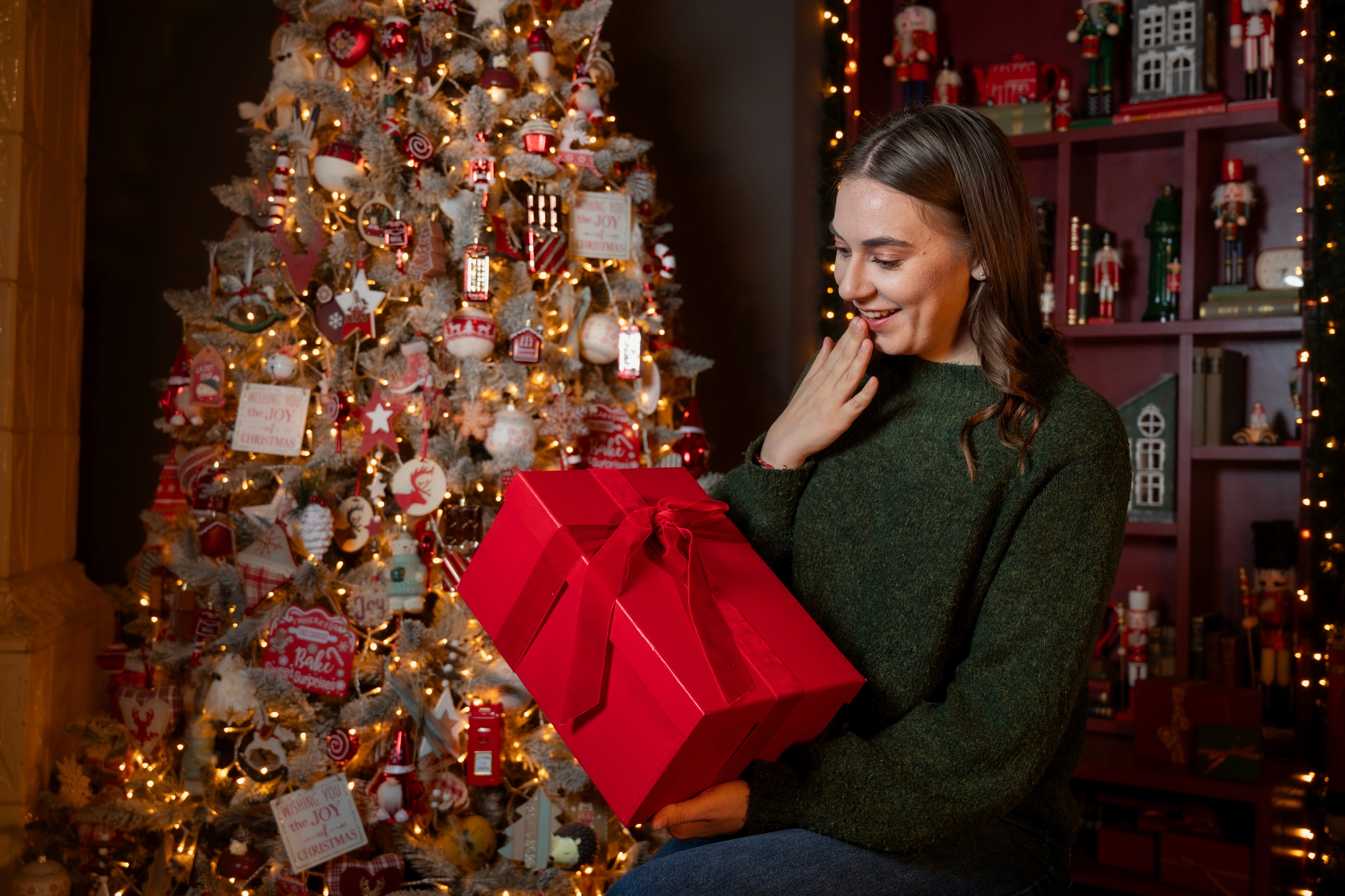 Portret feminin de Crăciun cu cadou, decor festiv și expresie naturală