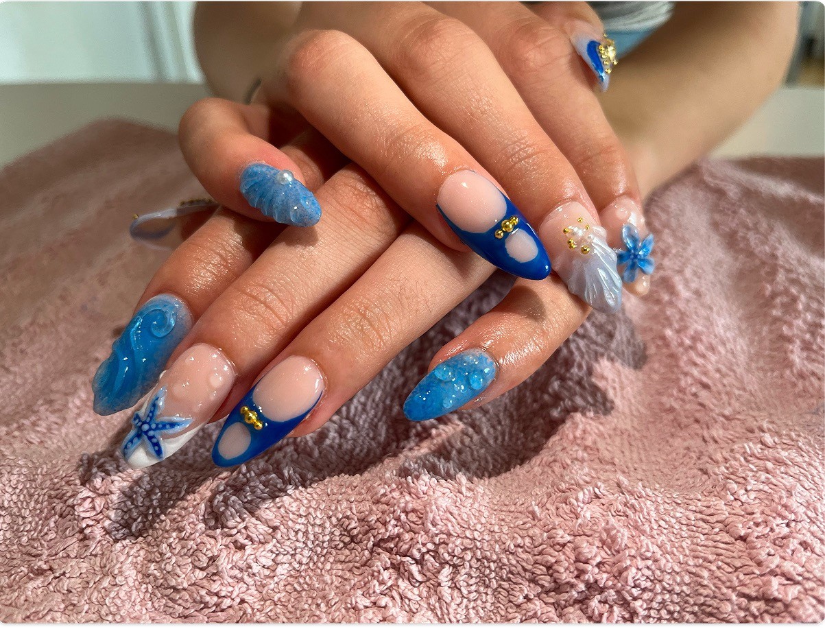Hand with pink swirl nails and rings in car