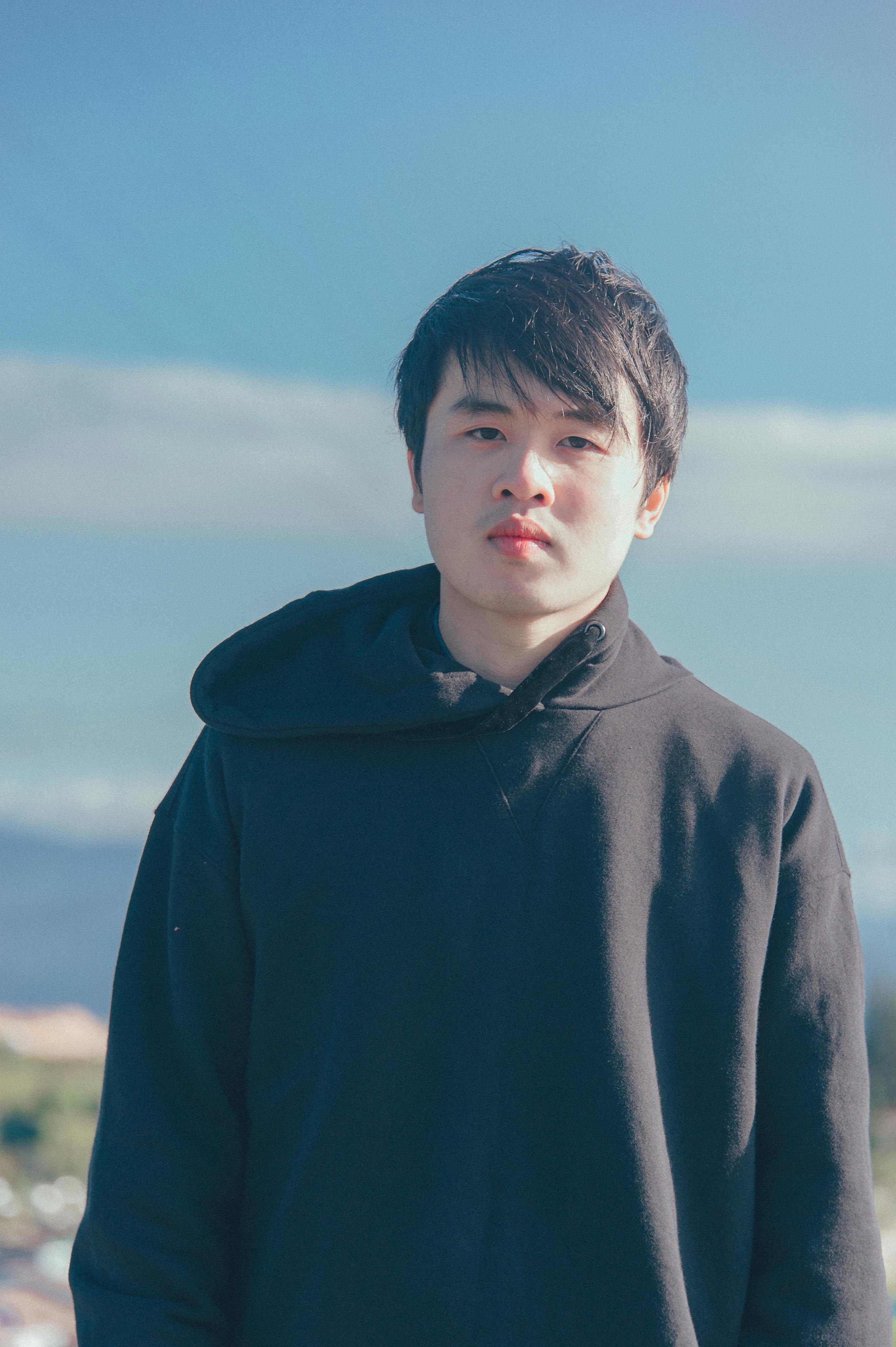 Person wearing hoodie against cloudy sky