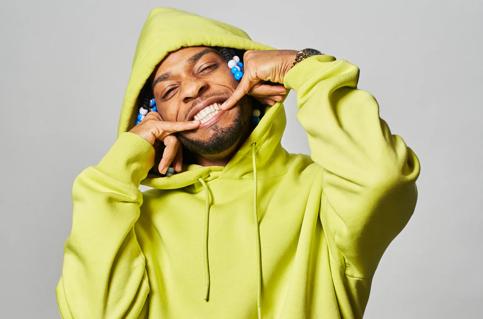 Armani White smiling in a lime green hoodie