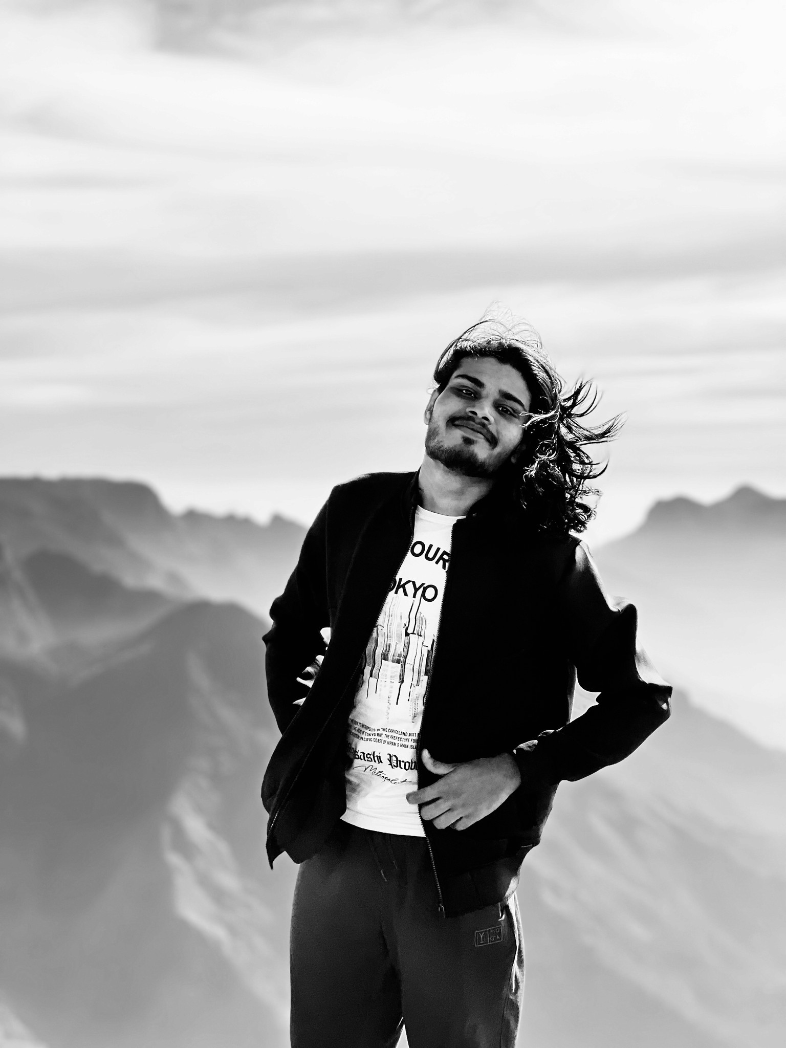 Portrait of man looking to the left and smiling with a dark background