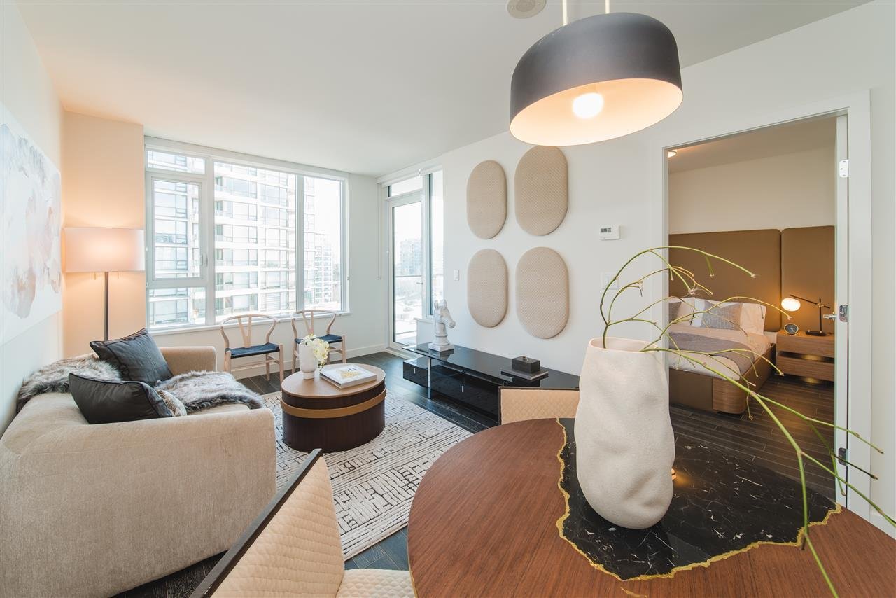 A bright living room featuring modern furniture, large windows, and a stylish lamp, creating a cozy atmosphere.