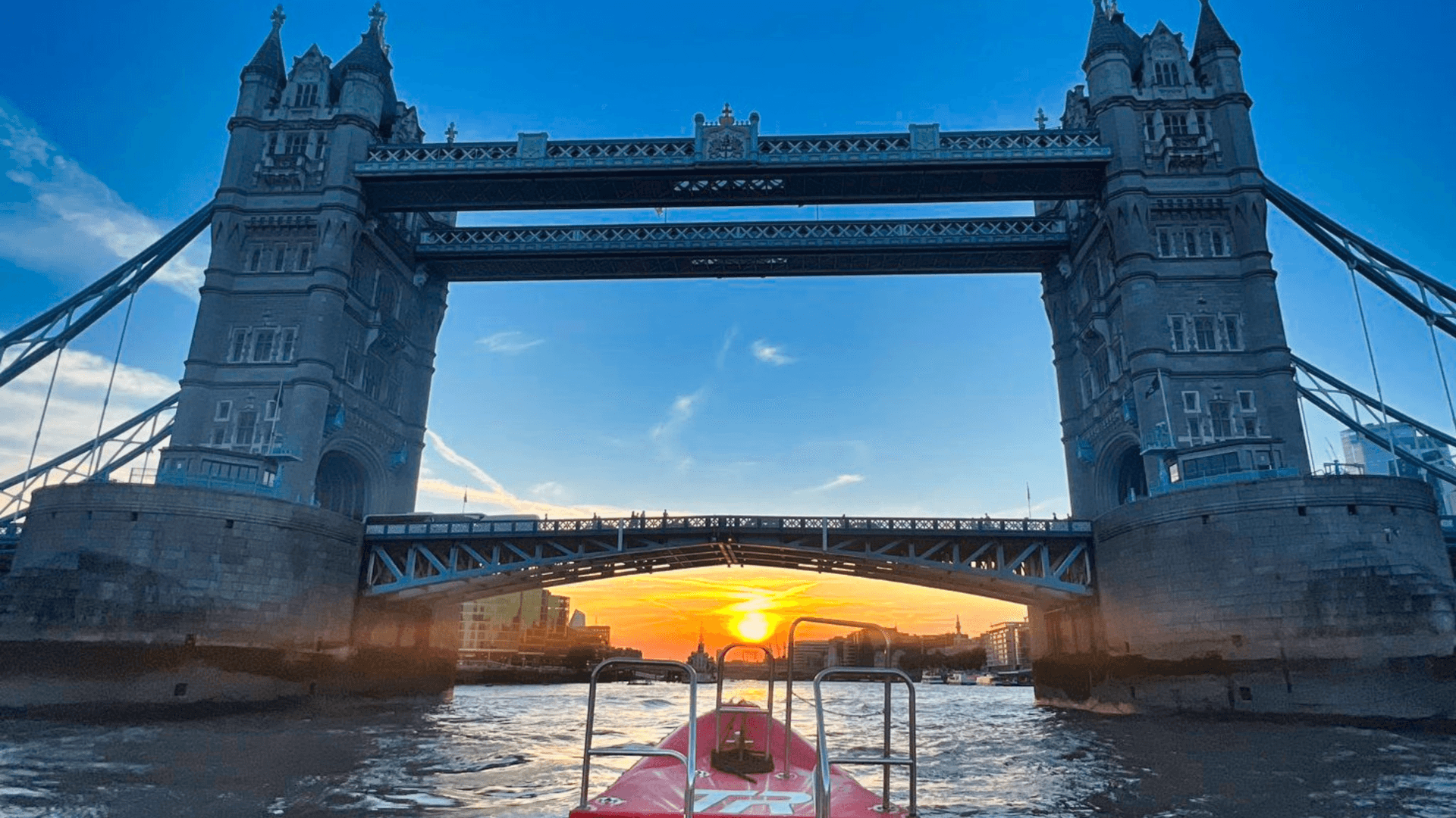 Thames Rockets Nights Speedboat Experience: The tip of the Thames Rocket RIB speeds points to the setting sun under Tower Bridge