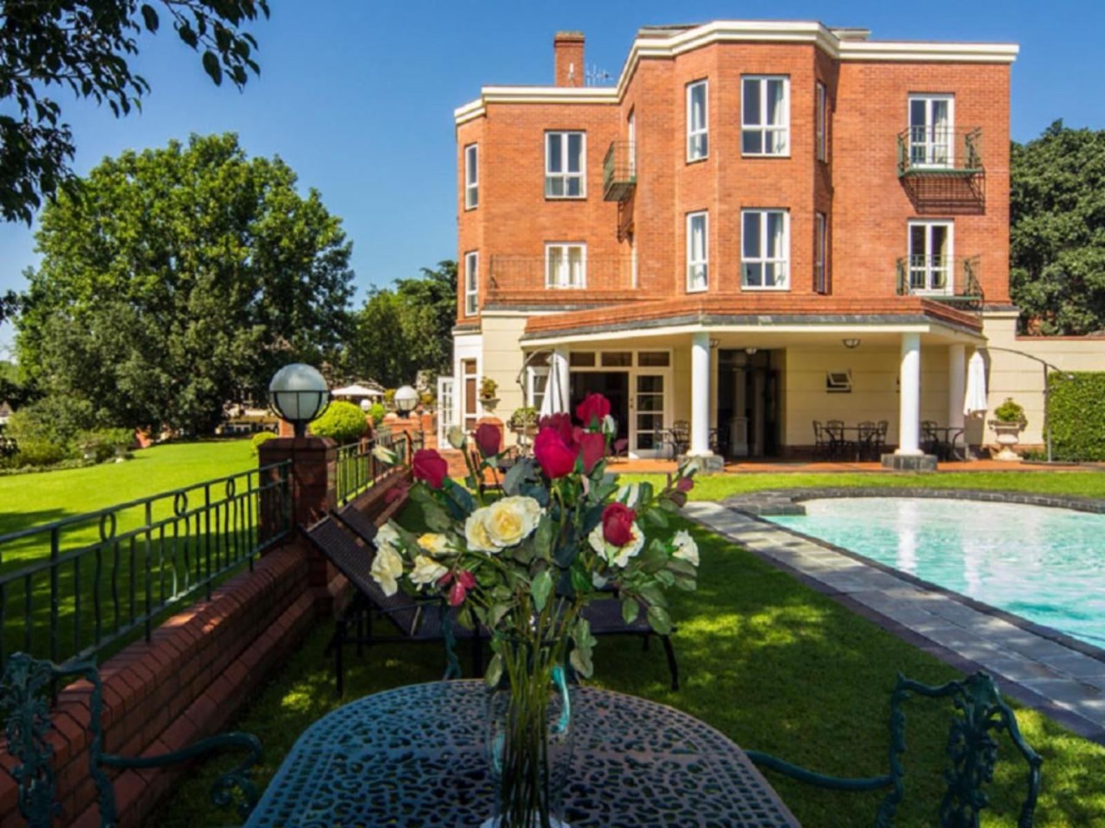 Sparkling outdoor swimming pool surrounded by lush gardens at Redlands Hotel.