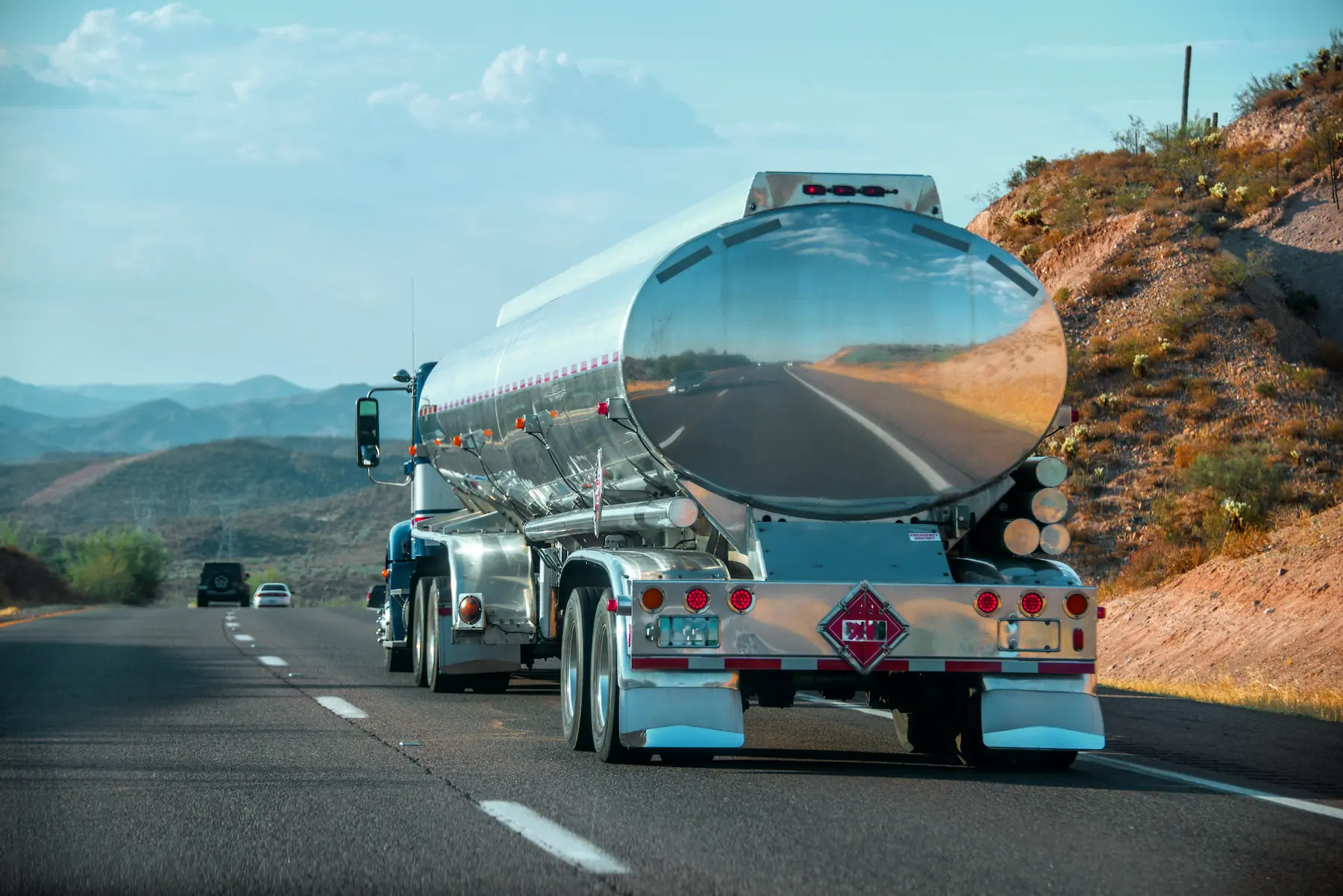 Tanker truck hauling fuel on a desert highway, reflecting the open road and blue sky — used on the GIA Group, LLC insurance carriers page to illustrate trucking industry coverage.