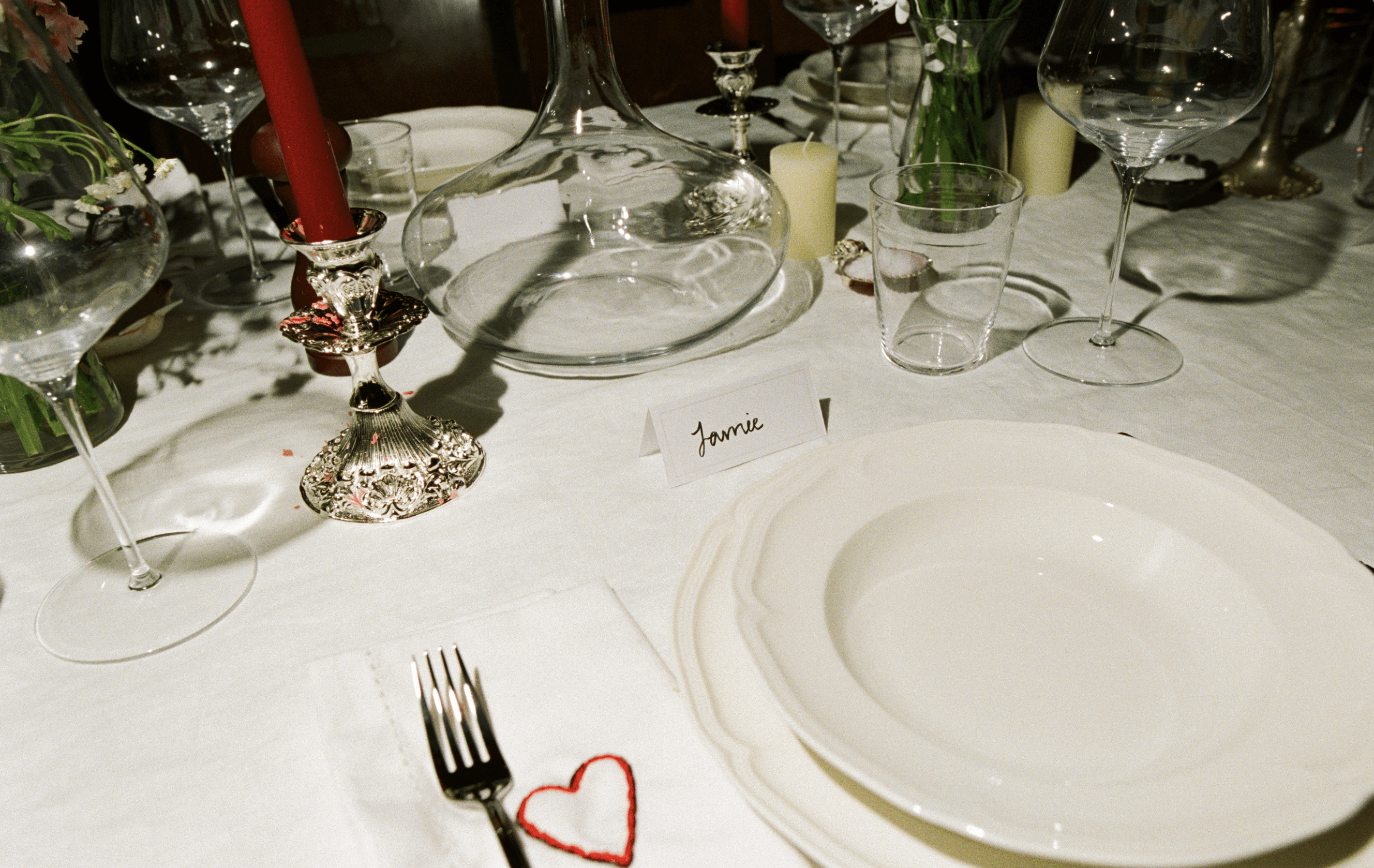 A decorative floral arrangement spills over a table draped in red fabric, creating an elegant atmosphere.